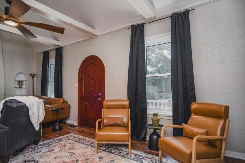 Whimsical Historic Getaway Near Golf Skiing and Wisconsin Southern Lakes في Genoa City: غرفة نوم بها سرير وكراسي ونافذة