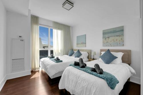 a bedroom with two beds with towels on them at Lakeview Unit - sleeps 11 people near CN Tower Union Rogers Centre and Convention Centre in Toronto