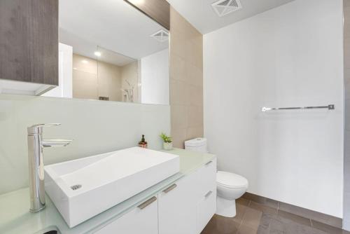 a white bathroom with a sink and a toilet at Lakeview Unit - sleeps 11 people near CN Tower Union Rogers Centre and Convention Centre in Toronto
