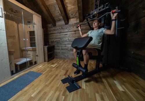 a man on a exercise bike in a gym at Eirl DOLOMITES Retreat Sappada in Sappada