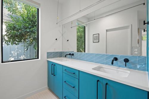 ein Badezimmer mit einem blauen Waschbecken und einem Spiegel in der Unterkunft Modern Luxury in the Heart of Austin 3BR 3BA with Huge Balcony in Austin