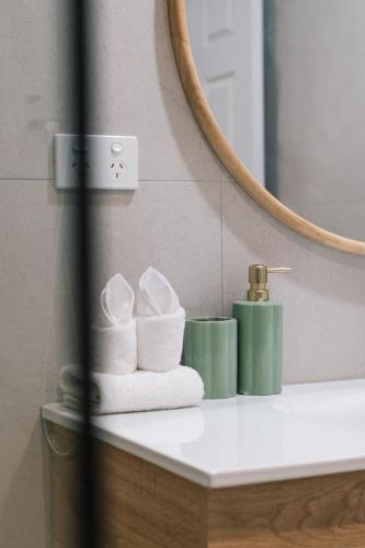 a bathroom counter with towels and a mirror at Nature Escape Acreage Forest Life and Pet Friendly in Boronia Heights