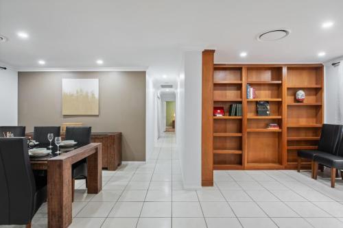 a living room with a table and chairs and a book shelf at Nature Escape Acreage Forest Life and Pet Friendly in Boronia Heights