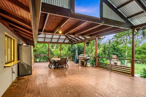 an open patio with a table and chairs on a deck at Nature Escape Acreage Forest Life and Pet Friendly in Boronia Heights