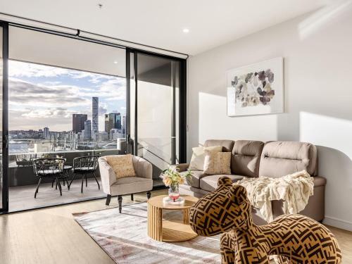 a living room with a couch and a view of the city at Stylish 2BR Unit with Pool and Gym in South Brisbane in Brisbane