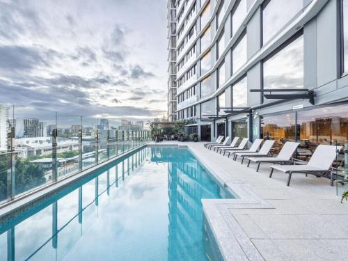 a swimming pool on the side of a building at Stylish 2BR Unit with Pool and Gym in South Brisbane in Brisbane