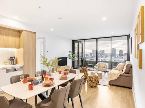 a kitchen and living room with a table and chairs at Stylish 2BR Unit with Pool and Gym in South Brisbane in Brisbane