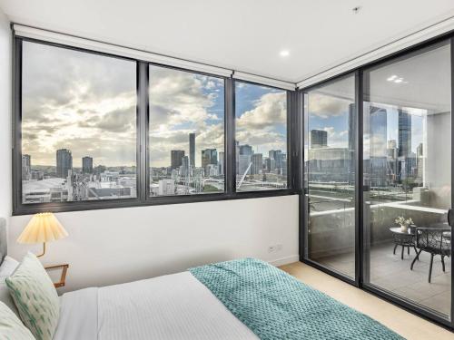 a bedroom with a view of a city skyline at Stylish 2BR Unit with Pool and Gym in South Brisbane in Brisbane