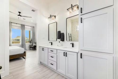 a white bathroom with a sink and a mirror at Beachfront Retreat - 4BR with Ocean Views and Parking in Bolivar Peninsula