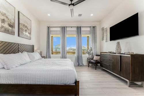 a bedroom with a bed and a flat screen tv at Beachfront Retreat - 4BR with Ocean Views and Parking in Bolivar Peninsula