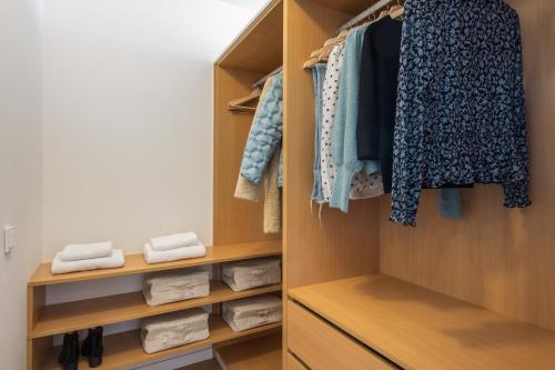 マドリードにあるWaou Plaza de España V - Alquiler Corta Duraciónのウォークインクローゼット(木製の棚、衣類付)
