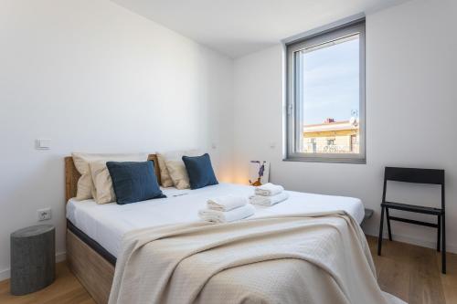 マドリードにあるWaou Plaza de España V - Alquiler Corta Duraciónの白いベッドルーム(大型ベッド、タオル付)