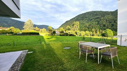 a table and chairs on a lawn with mountains in the background at Charming apartment with garden & parking in Sessa
