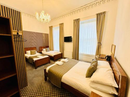 a hotel room with two beds and a living room at Sandyford Lodge in Glasgow