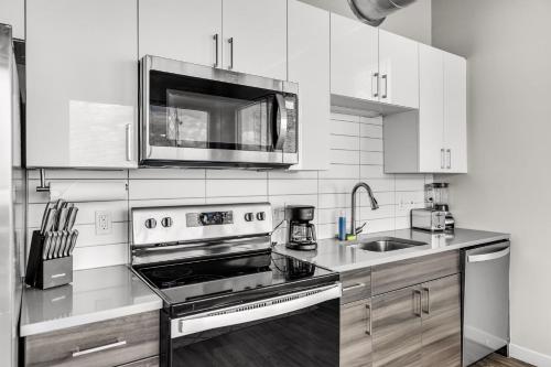 a kitchen with a stove and a microwave at Tropicana Field 1 Bed in Downtown With Free Parking in St Petersburg