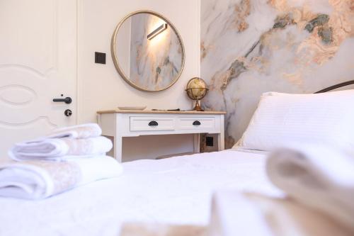 a bedroom with a bed with a mirror on the wall at Luce al Centro in Corfu