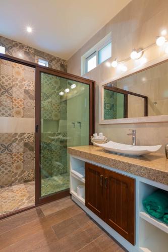 a bathroom with a sink and a glass shower at Villas Comodoro in Isla Mujeres