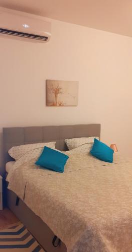 ein Schlafzimmer mit zwei Betten und blauen Kissen in der Unterkunft Studio Leonidas Vis in Vis
