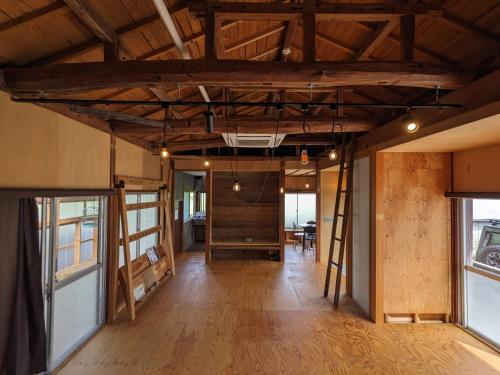 an empty room with a wooden floor and wooden ceilings at コワーキングスペース kuzume Base ゲストハウス 古朴-MOKU-1棟貸の宿 in Konan