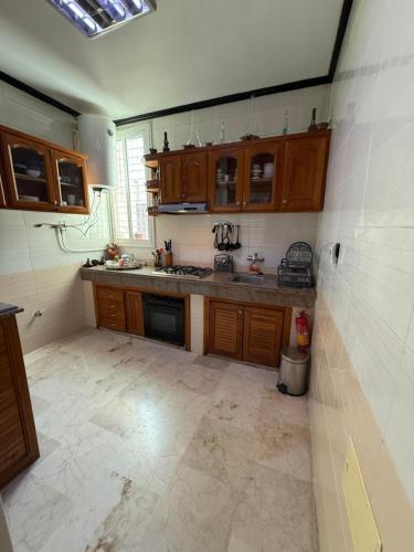 a kitchen with wooden cabinets and a tile floor at Appartement Luxe Simo in Fès
