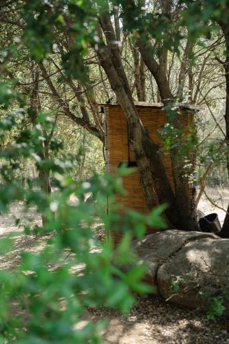a brick building with a tree on top of a rock at A Malgrana - Tente lodge hébergement insolite in Coti-Chiavari