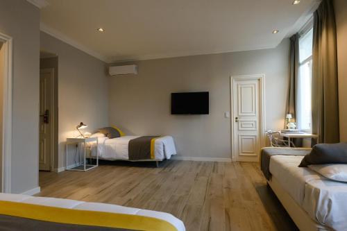 a hotel room with two beds and a couch at Midtown Boutique Hotel in Buenos Aires