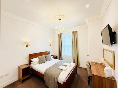 a hotel room with a bed and a television at Sandyford Lodge in Glasgow