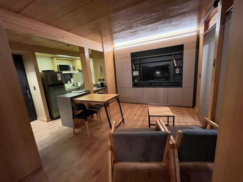 a living room with a table and chairs and a television at Monoambiente centrico con jardin in San Martín de los Andes