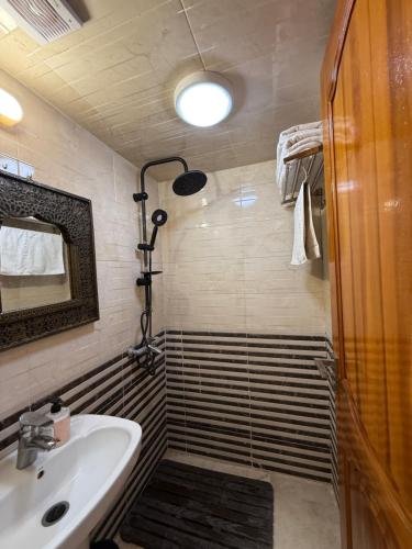 a bathroom with a shower and a sink and a mirror at Appartement Luxe Simo in Fès