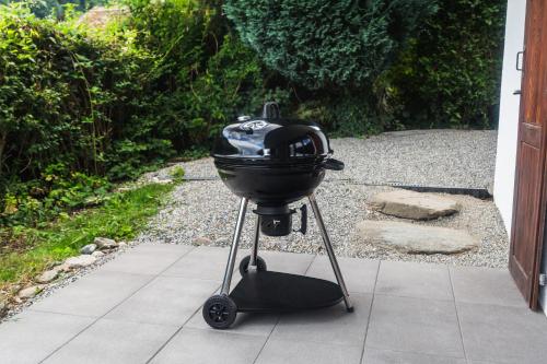a grill on a stand in front of a door at Chalet cosy au pied des Portes du Soleil in Troistorrents