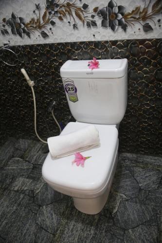 a toilet with two towels on top of it at Hiruni Cottage Ella in Ella