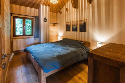 a bedroom with a bed and a wooden floor at Chalet cosy au pied des Portes du Soleil in Troistorrents
