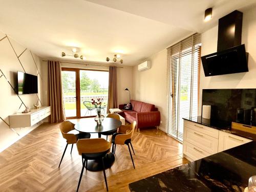a living room with a table and chairs at Apartament River in Pisz