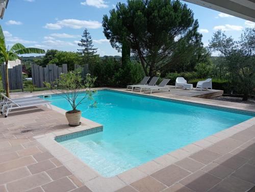 a swimming pool with chairs and a potted plant at Suite Antonin in La Sauvetat-sur-Lède