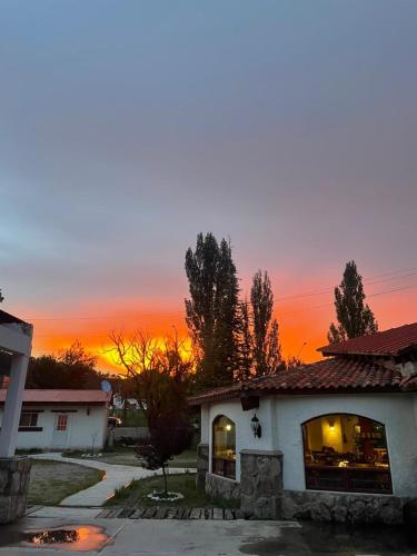 a house with a sunset in the background at Hotel Quinta Mision in Creel
