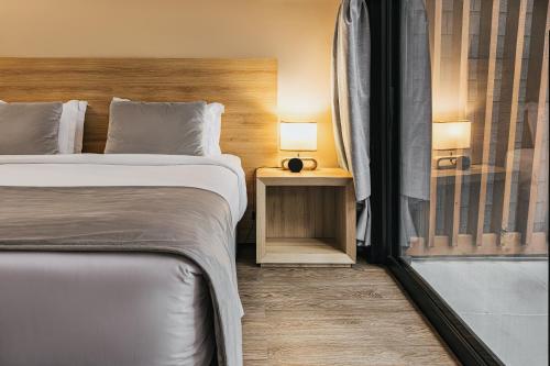 a hotel room with two beds and a window at Hotel Boutique Vinícola Araucária by Slaviero Hotéis in São José dos Pinhais