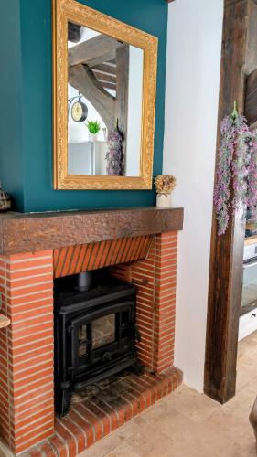 a fireplace with a mirror on top of it at Gîte des champs étoilés in Thuboeuf