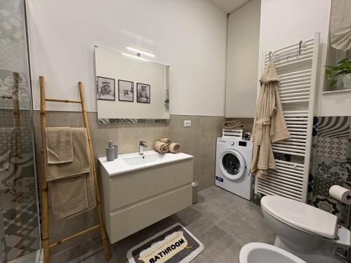 a bathroom with a sink and a washing machine at Il Giardino Nascosto in Trieste