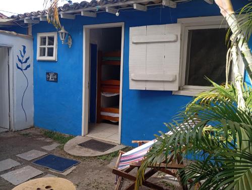 a blue house with a window and a door at Raizes Chill House in Búzios