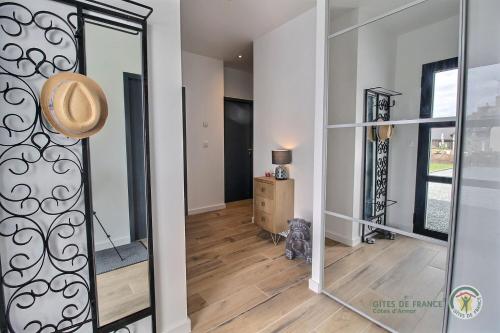 a hallway with a mirror and a dog in a room at Enez terc'h in Plougrescant