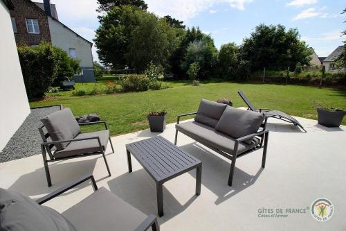 two chairs and a table on a patio at Enez terc'h in Plougrescant