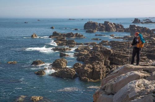 a man standing on the rocks near the ocean at Enez terc'h in Plougrescant