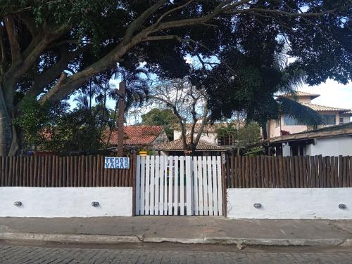 a white fence in front of a house at Raizes Chill House in Búzios