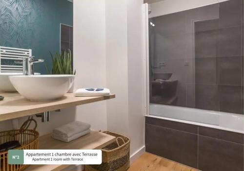 een badkamer met een wastafel en een ligbad bij La Villa du Bois d'Amour in Quiberon