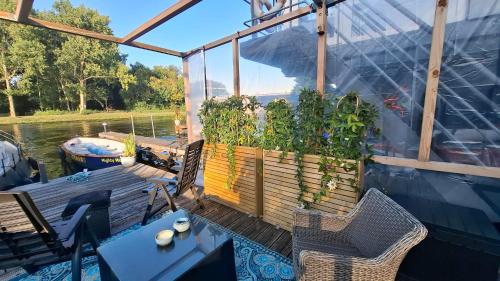 a deck with chairs and plants on a boat at B&B Aquamarijn Katwijk in Katwijk aan Zee
