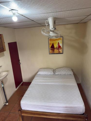 a bed in a room with a ceiling at Hostal Los Chamos in San Juan del Sur