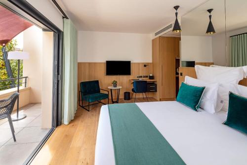 a hotel room with a bed and a balcony at Hôtel Sainte Victoire in Vauvenargues