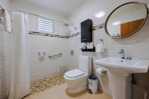 a bathroom with a toilet and a sink and a mirror at Ulala Culebra in Culebra