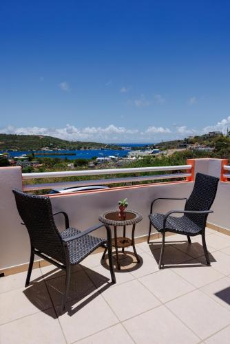 a patio with three chairs and a table on a balcony at Ulala Culebra in Culebra