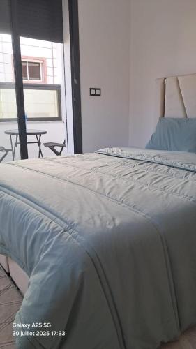 a white bed in a room with a table at modern apartment in Tangier